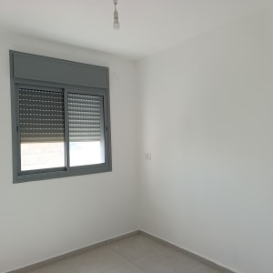 חדר ריק עם קיר לבן וחלון אפור