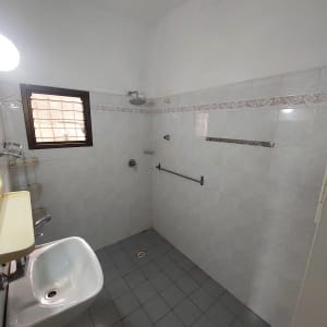 חדר אמבטיה עם כיור, מקלחת, ואריחים על הקירות