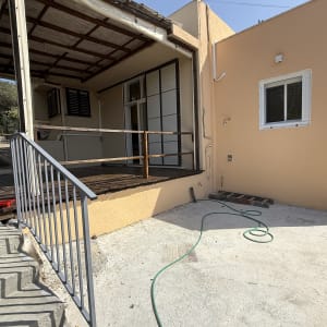 מעקה מתכת אפור מותקן לצד מדרגות בכניסה לבית