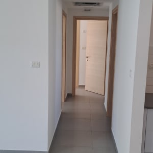 מסדרון עם קירות לבנים ודלתות עץ