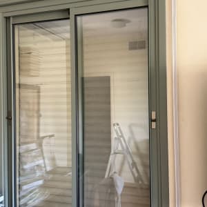 חלון זכוכית עם תריסים וסולם ברקע