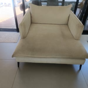 ספה בהירה ליד חלון זכוכית עם נוף חיצוני