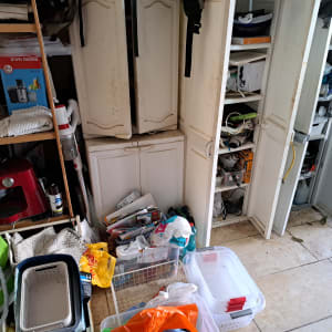 חדר אחסון מבולגן עם ארונות פתוחים וקופסאות פלסטיק