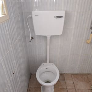 אסלה מותקנת בחדר אמבטיה עם אריחים