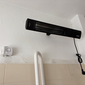 תנור חימום חשמלי תלוי על קיר עם כבל חשמל