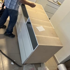 אדם עובד על הרכבת רהיט עם כלים וחומרים מסביב
