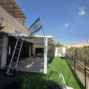 מרפסת עם דשא סינטטי ודגל ישראל