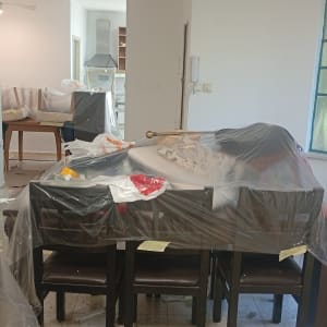 חדר עם רהיטים מכוסים בניילון, דלי צבע על הרצפה