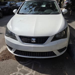 מכונית לבנה חונה ברחוב עם עצים ברקע