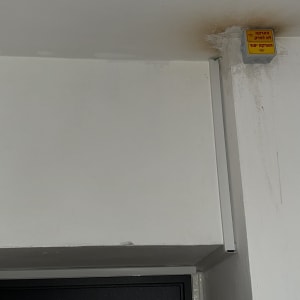 קופסת חשמל מותקנת על קיר עם סימני חלודה