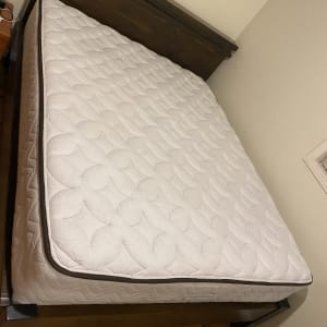 מזרן לבן על מיטה עם מסגרת עץ כהה