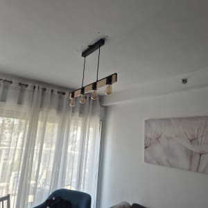 מנורת תקרה עם ארבע נורות תלויה בחדר מגורים.