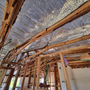 גג עם קורות עץ ובידוד מתכתי מבריק