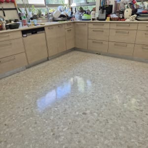 מטבח נקי עם רצפה מבריקה וכלים על השיש