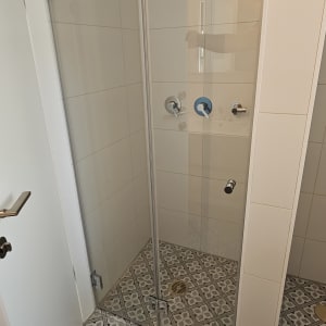 מקלחת עם ראש גשם ודלת זכוכית