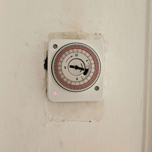 שעון טיימר מותקן על קיר, חלק מעבודת חשמל