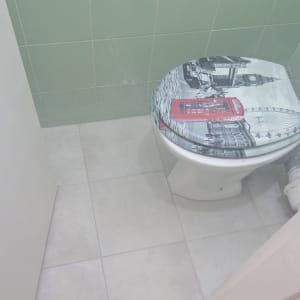אסלה עם מכסה מעוצב וריצוף חדש בחדר שירותים