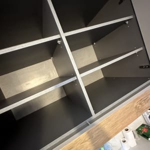 מוצרי ניקוי ומגבות נייר ליד ארון פתוח