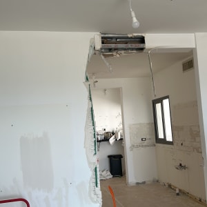 חדר בשיפוץ עם קיר שבור, כלי עבודה על הרצפה