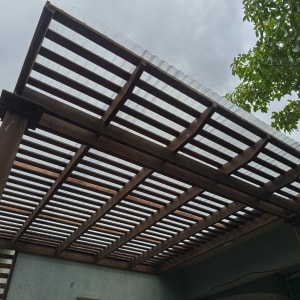 פרגולה מעץ עם גג שקוף בחצר