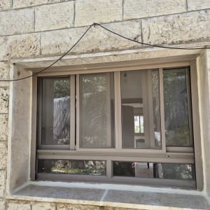 חלון אטום עם מסגרת מתכת בקיר אבן