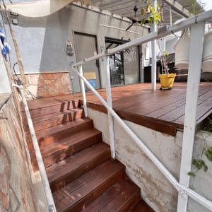 מדרגות עץ ומרפסת עם צמחייה תלויה