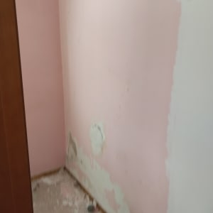 קיר ורוד מתקלף עם סימני תיקון