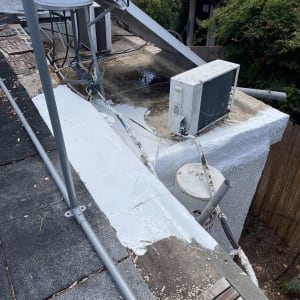 איטום גג עם חומר לבן ליד מזגן