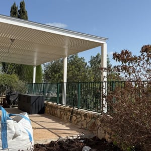 פרגולה אלומיניום בחצר עם צמחייה מסביב