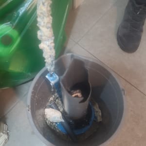 חלקי דוד שמש עם אבנית בתוך דלי על הרצפה