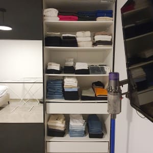 ארון בגדים מסודר עם בגדים מקופלים על מדפים