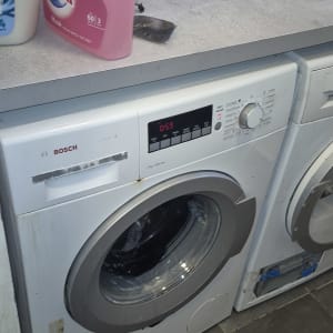 מכונת כביסה עם חומרי ניקוי על השיש