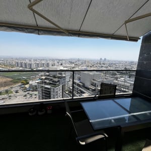 מרפסת עם סוכך נוף עירוני שולחן וכיסאות