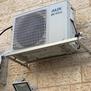 יחידת מזגן חיצונית מותקנת על קיר אבן