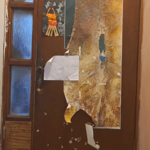 דלת עץ עם פוסטרים ומפת ישראל מודבקים עליה