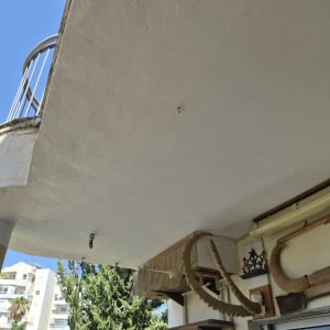 מרפסת עם מעקה וחפצים תלויים על הקיר
