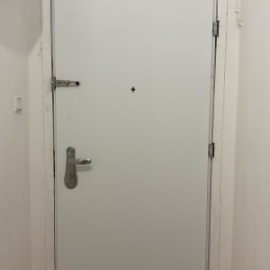 דלת לבנה עם ידית מתכת ובריח
