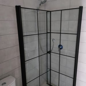 מקלחון זכוכית עם מסגרת מתכת וברז מקלחת