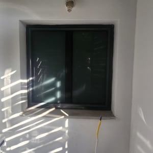 חלון עם מסגרת אלומיניום וקיר לבן