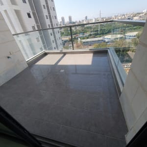 מרפסת עם רצפה נקייה ומעקה זכוכית