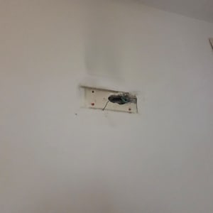 חוטי חשמל יוצאים מקיר עם שקע פתוח