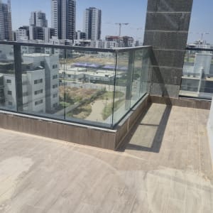 מרפסת עם מעקה זכוכית ונוף לעיר
