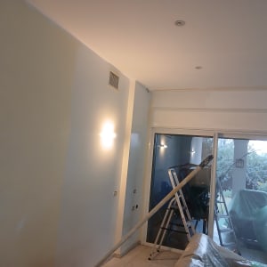 קיר צבוע עם סולם וכלי עבודה לצביעה