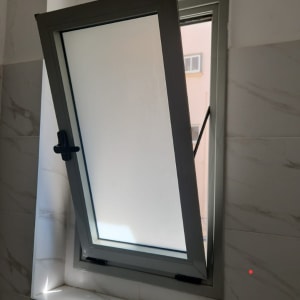 חלון פתוח עם מסגרת מתכת בחדר אמבטיה