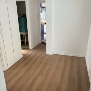 רצפת פרקט עץ בחדר ריק עם קירות לבנים