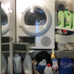 מכונת כביסה ומייבש עם חומרי ניקוי על מדף
