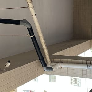 צינורות פלסטיק שחורים ולבנים מחוברים לקיר