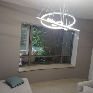 חדר עם קיר צבוע, חלון גדול ומנורה מודרנית