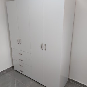 ארון לבן עם ידיות מתכת בחדר