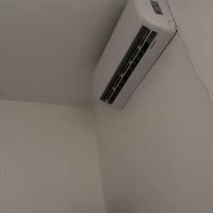 מזגן מותקן על קיר בחדר עם מדפים